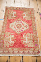 Vintage Distressed Oushak rug's central serrated medallion, displaying raspberry, beige, and pink tones.