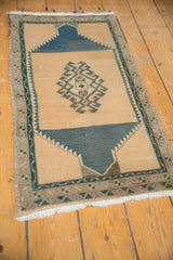 Distressed vintage Oushak runner corner with dusty navy serrated contour, geometric border, and low pile.
