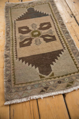 Distressed Oushak rug lower right corner, showing white fringe and brown serrated field edge.