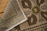 Distressed Oushak rug's worn sand, chocolate, green pile alongside its hand knotted reverse.