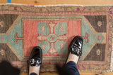 Evenly worn pile of a distressed Turkish Oushak rug in blush, seafoam green, and brown.