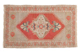 Distressed hand-knotted vintage Oushak rug with brick red medallion and ivory field.