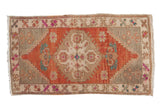 Hand knotted distressed Oushak mat with abrashed brick red medallion and vibrant florals.