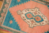 Stepped turquoise spandrel with apricot peach field of a vintage Oushak rug.