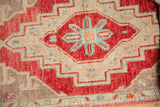 Distressed Oushak rug pile with cherry red, ivory, and blue stepped geometric pattern.