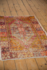 Worn pile of a distressed Oushak rug, featuring aubergine, saffron, and pink hues.