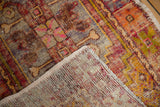 Distressed Oushak rug corner revealing secured edge, woven foundation, and variegated pile.