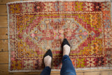 Worn texture of a distressed Oushak rug, showcasing stepped medallion in aubergine, gold, pink.
