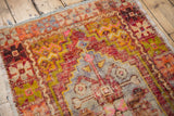 Distressed vintage Oushak rug with even wear, featuring stepped pink, gold, and mauve motifs.