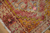 Distressed hand-knotted Oushak rug pile, showcasing saffron, gold, aubergine, pink hues and worn texture.