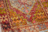Distressed Oushak rug pile with stepped geometric motifs in aubergine, gold, and pink.