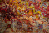 Distressed vintage Oushak rug pile with visible knot heads and vibrant saffron, gold, and aubergine hues.