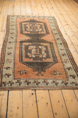 Distressed texture and geometric starburst border of a vintage Oushak rug in terra cotta and brown.