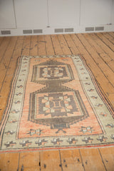 Distressed low pile on vintage Oushak rug border, showing terra cotta and brown geometric motifs.