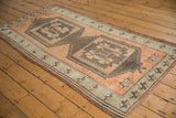 Distressed pile detail on a hand-knotted vintage Oushak rug, showing terra cotta starburst border.