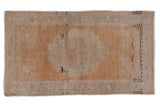 Distressed vintage Oushak rug with pale terra cotta field, abrash, and floral roundel medallion. 3'2