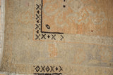 Corner detail of vintage distressed Oushak rug, with mostly even wear, fringe, and geometric border.