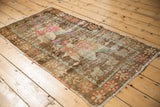 Distressed vintage Oushak rug pile with blush pink and sea foam green floral motifs.