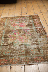 Vintage distressed Oushak rug texture with worn floral motifs in blush, bronze, and seafoam.