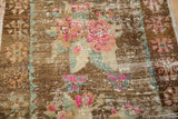 Distressed vintage Oushak rug pile close-up, revealing foundation and vibrant pink florals.