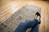 Vintage Oushak runner, geometric pattern in faded rose, silver, brown, showing visible knot heads.