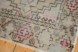Geometric coffee brown and bright pink patterns with worn silver pile on Oushak rug.