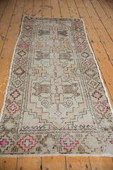 Corner of the distressed Oushak runner, highlighting textured geometric motifs in pink and coffee brown.