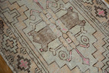 Textured pile of vintage distressed Oushak rug with geometric floral motifs and blush pink accents.