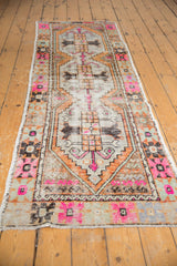 Distressed vintage Oushak runner's geometric patterns, bright bubble gum pink, and mostly even wear.