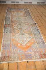 Distressed Oushak runner detail with tangerine, lavender, and floral stepped patterns.