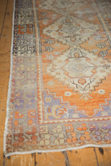 Distressed Oushak runner border with tangerine and aubergine geometric motifs.