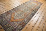Distressed Oushak runner with faded tangerine and blue stepped medallion motifs.