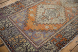 Decorative distressed vintage Oushak rug border in tangerine, grey, and aubergine tones.