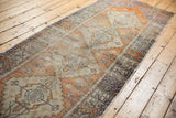 Distressed Oushak runner close-up, highlighting tangerine orange florals and softened pile.