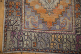 Distressed Oushak runner border detail with faded tangerine, lavender, and greige motifs.
