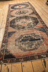 Distressed vintage Oushak rug close-up shows worn knot heads, blush, charcoal, and exposed foundation.