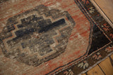 Distressed Oushak rug detail: faded charcoal, blush, navy gul patterns, and visible foundation.