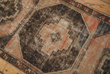 Distressed Oushak rug detail: worn gul medallion in dusty blush, charcoal, and navy.