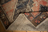 Distressed vintage Oushak runner's worn pile and exposed hand-knotted foundation in muted tones.