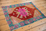 Worn pile of a vintage Oushak rug showing pink medallion and aqua geometric border.