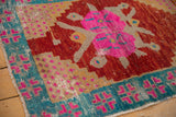 Textured vintage Oushak corner with pink medallion, aqua border, and cherry red field.