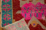 Distressed Oushak pile with bubblegum pink, red, aqua turquoise, and visible foundation.