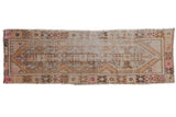Distressed vintage Oushak runner with elongated medallion, worn apricot, blush, and coffee brown tones, 2'6