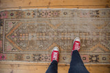 Faded apricot, blush, and coffee brown primitive floral motifs on a distressed Oushak runner.