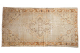 Vintage Distressed Oushak runner with ivory field, tangerine medallion, brown vine border.