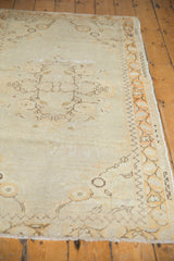 Distressed Oushak runner pile detail: aged ivory field, pale tangerine leaf border.