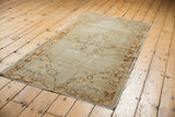 Distressed Oushak runner corner with antique ivory field and pale tangerine vine border.