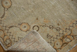 Distressed vintage Oushak rug corner, revealing hand-knotted pile, woven foundation, and fringe.