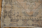 Distressed Oushak rug runner edge with geometric pattern, even wear, and soft fringe.