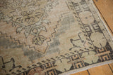 Distressed beige and sand Oushak runner, highlighting low pile, worn knot heads, and faded patterns.